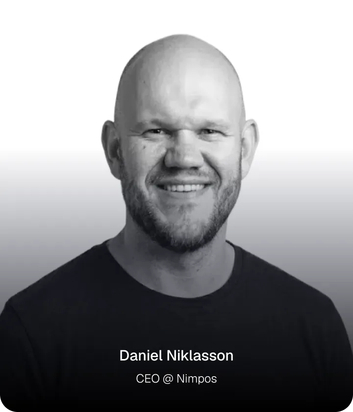 Portrait of Daniel Niklasson, CEO of Nimpos, smiling with a short beard and bald head against a white to gray gradient background.