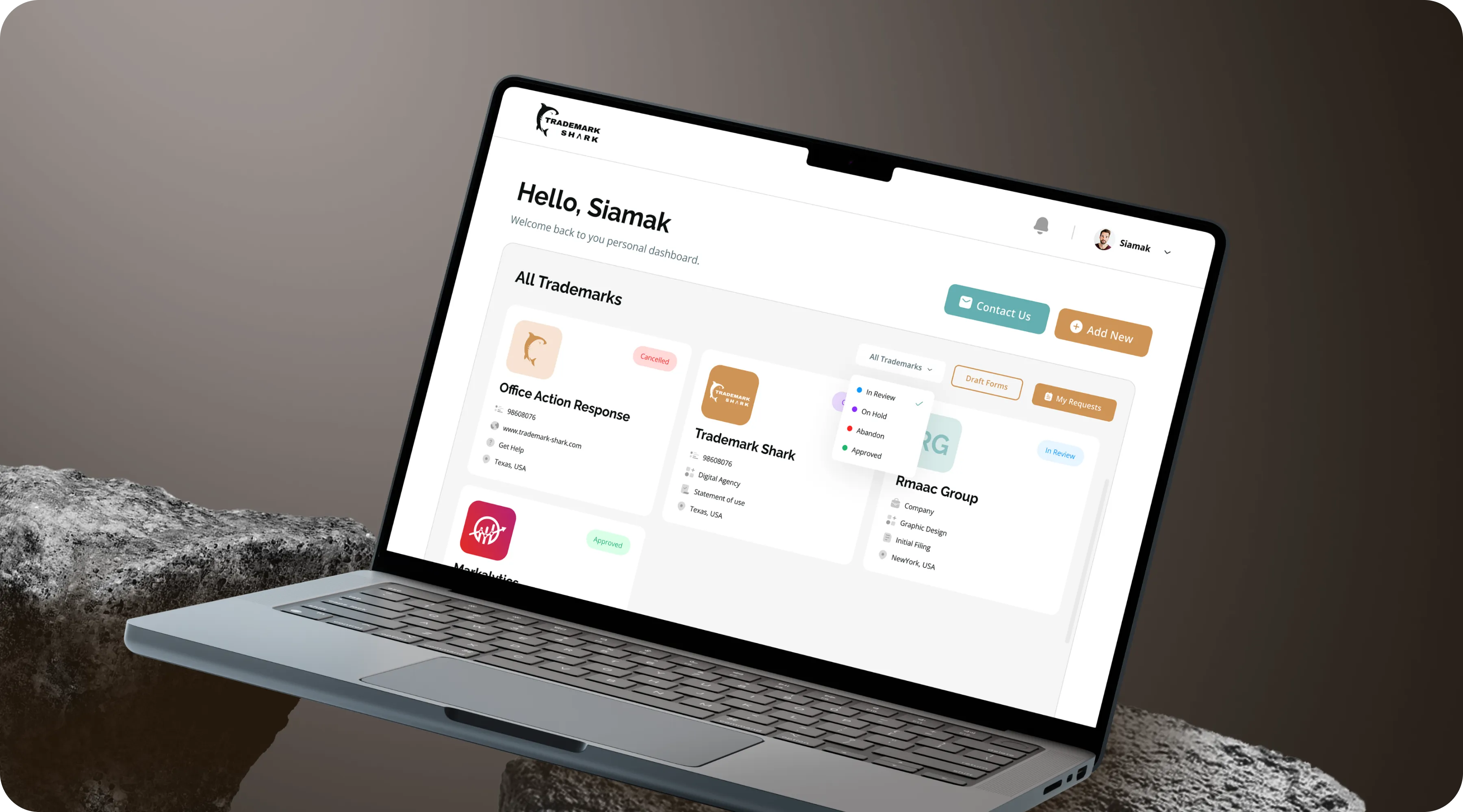 Person in yellow jacket using a laptop outdoors showing Scootsee e-scooter travel website in front of rocky mountainous scenery.