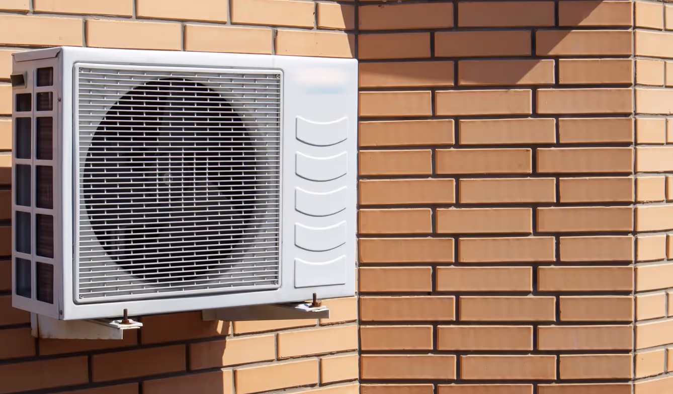 A single mini-split air conditioner unit mounted on a modern brick wall.