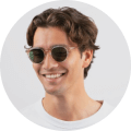 A man wearing sunglasses and a white shirt.