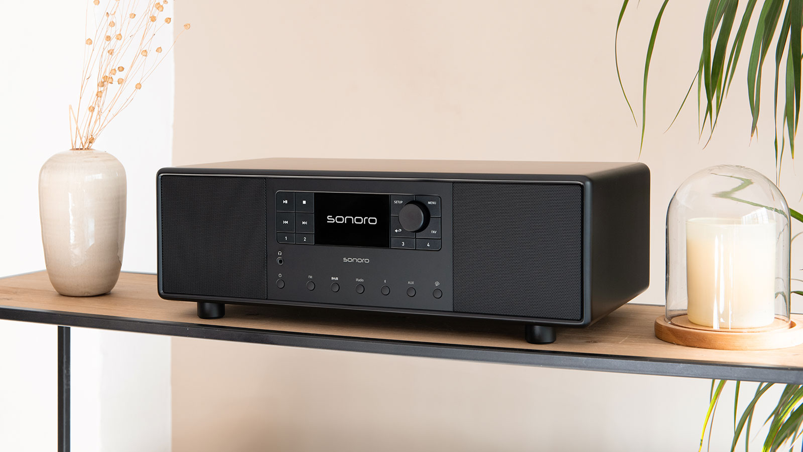 Schwarzes Sonoro-Musiksystem auf einem Regal, dekoriert mit Vase und Glashaube mit Kerze