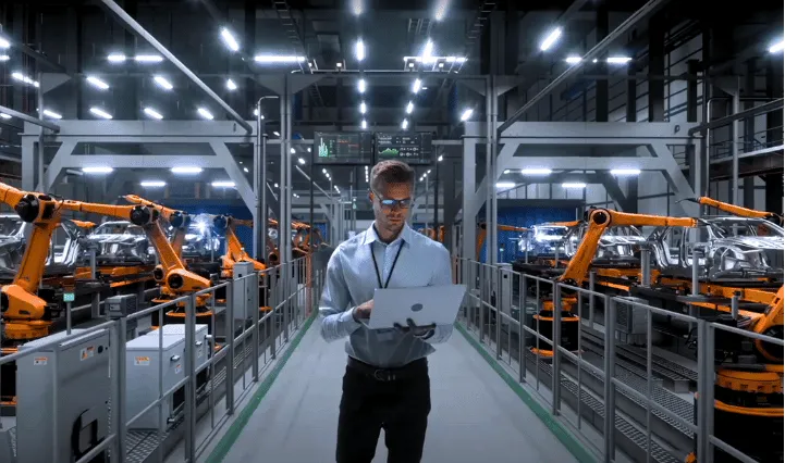 Person standing in factory with discrete parts surrounding them