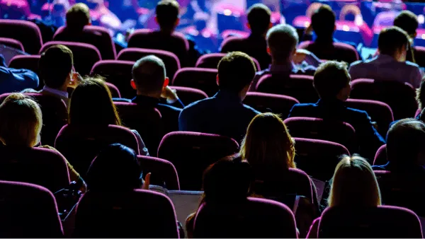 View of many people sitting in an event hall next to one another