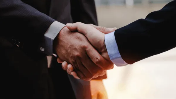 Two people shaking hands in a business setting