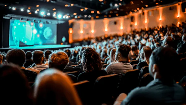 People sitting in a large conference room facing the stage
