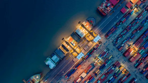 High-level view of cargo ships and vehicles next to the water