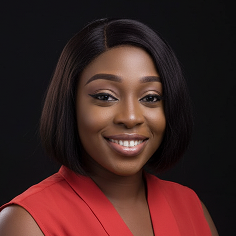 Smiling woman with straight black hair wearing a red sleeveless top against a black background.