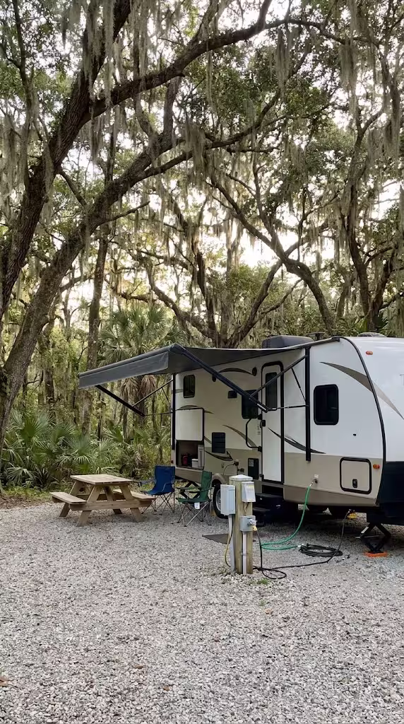 Travel trailer on a shaded full hookup campsite under live oaks near Crystal River, FL
