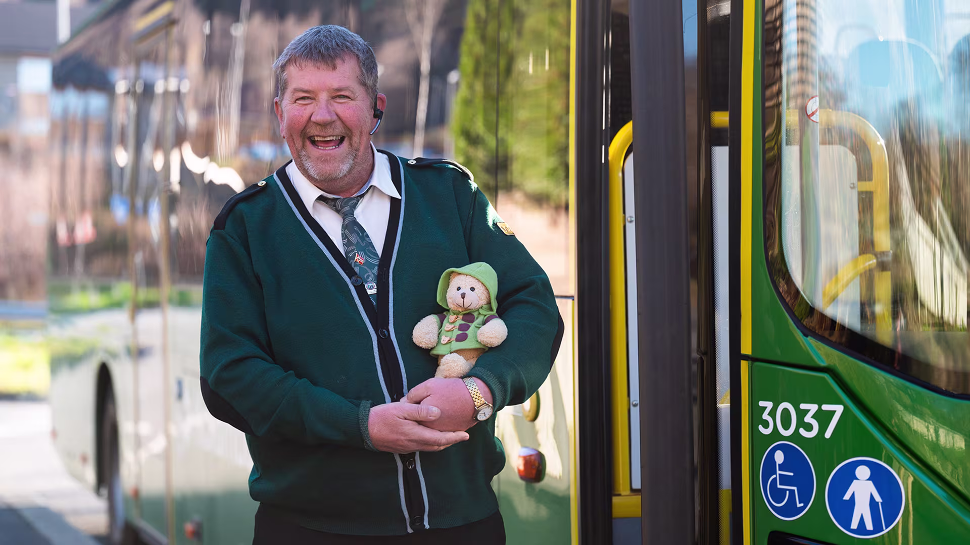 A happy bus driver in front of a Kolumbus bus
