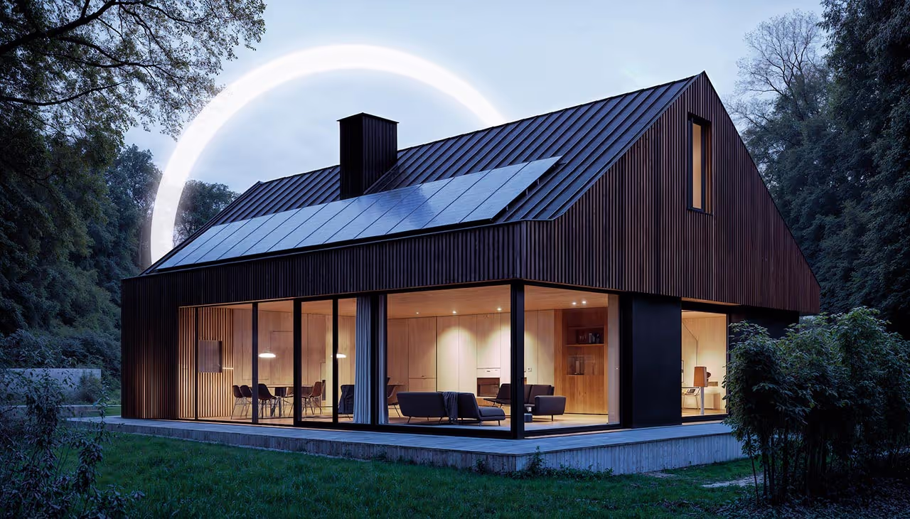 Modernes Holzhaus bei Dämmerung mit Solaranlage auf dem Dach, große Fensterfront mit warm beleuchtetem Innenraum, leuchtender Lichtkreis.