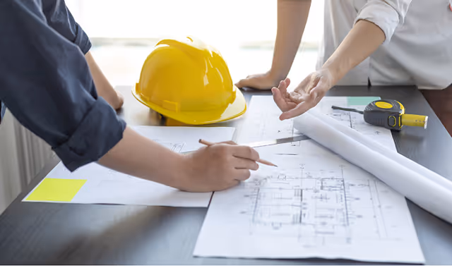 Beratung und Planung im Bauwesen – Projektteam arbeitet an Bauplänen