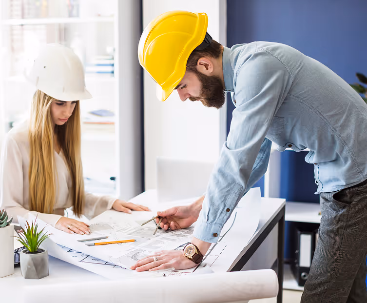 Ingenieurteam in Schutzhelmen prüft Baupläne – Planung und Baukoordination