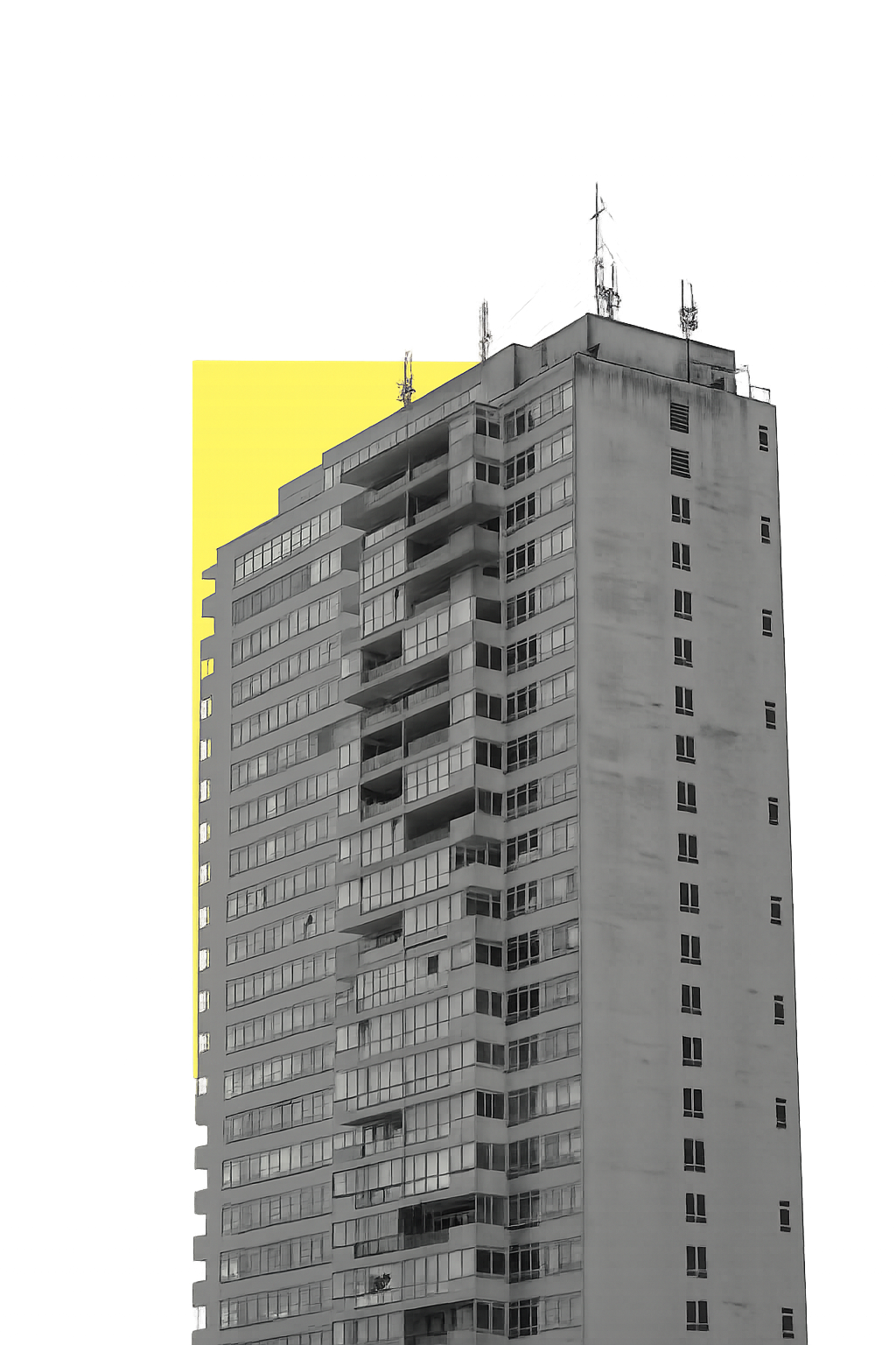 Tall gray building with antennas on top illuminated by a bright yellow light behind it.
