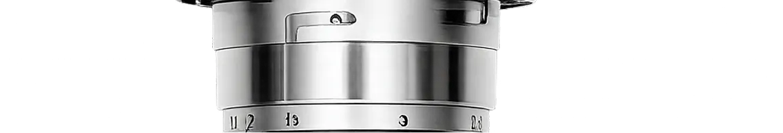 Close-up of a vintage silver camera lens with engraved aperture and focus markings.
