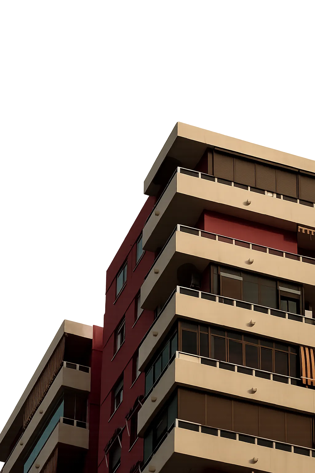 Modern apartment building with beige balconies and maroon walls under a dark moody sky.