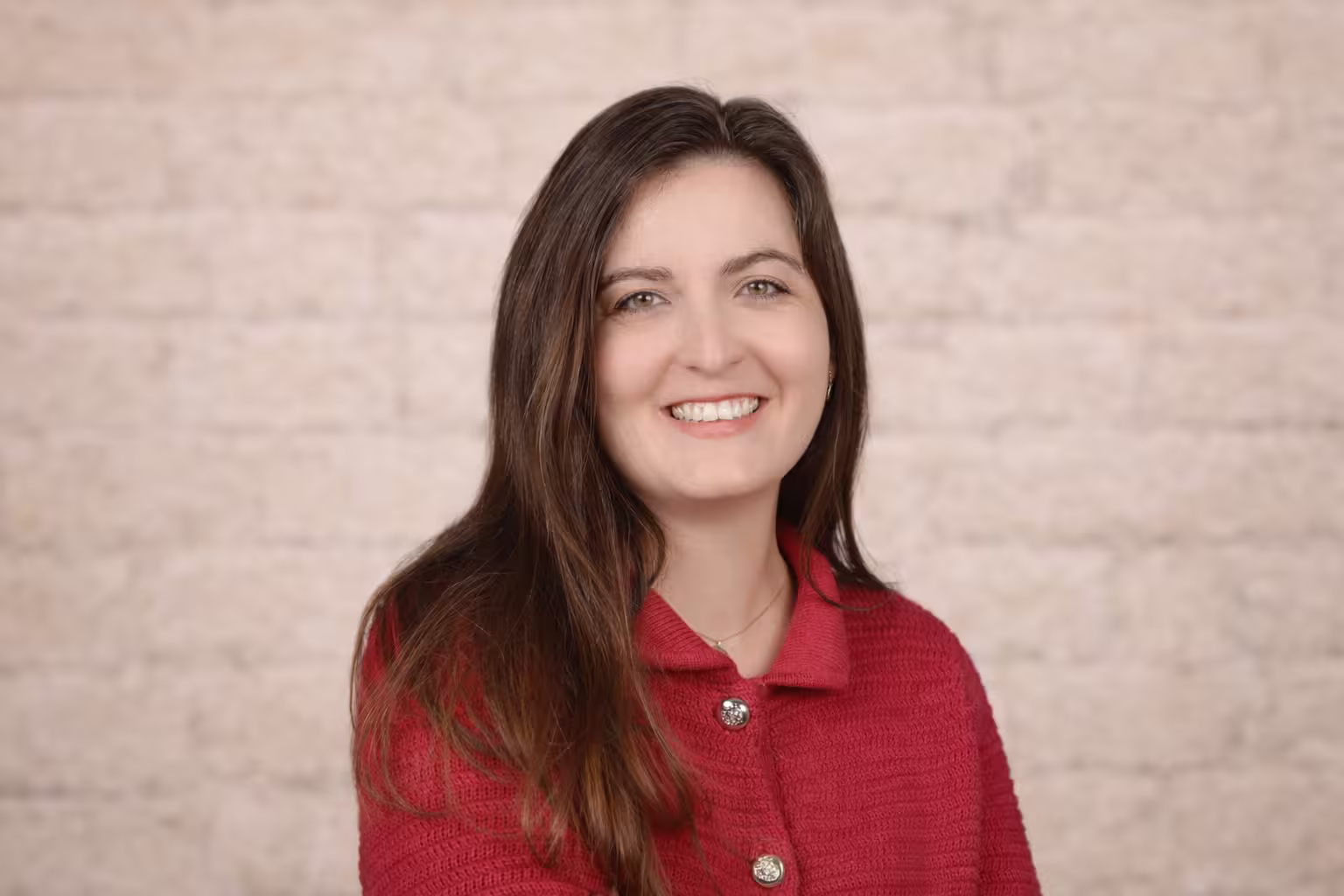 Middle-aged man with light beard and short hair wearing a white button-up shirt, standing outdoors with green foliage background.