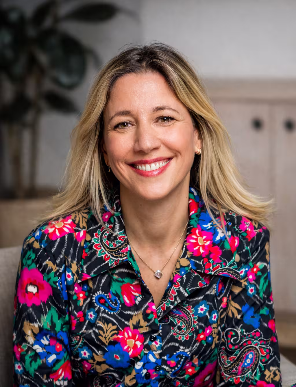 Middle-aged man with light beard and short hair wearing a white button-up shirt, standing outdoors with green foliage background.