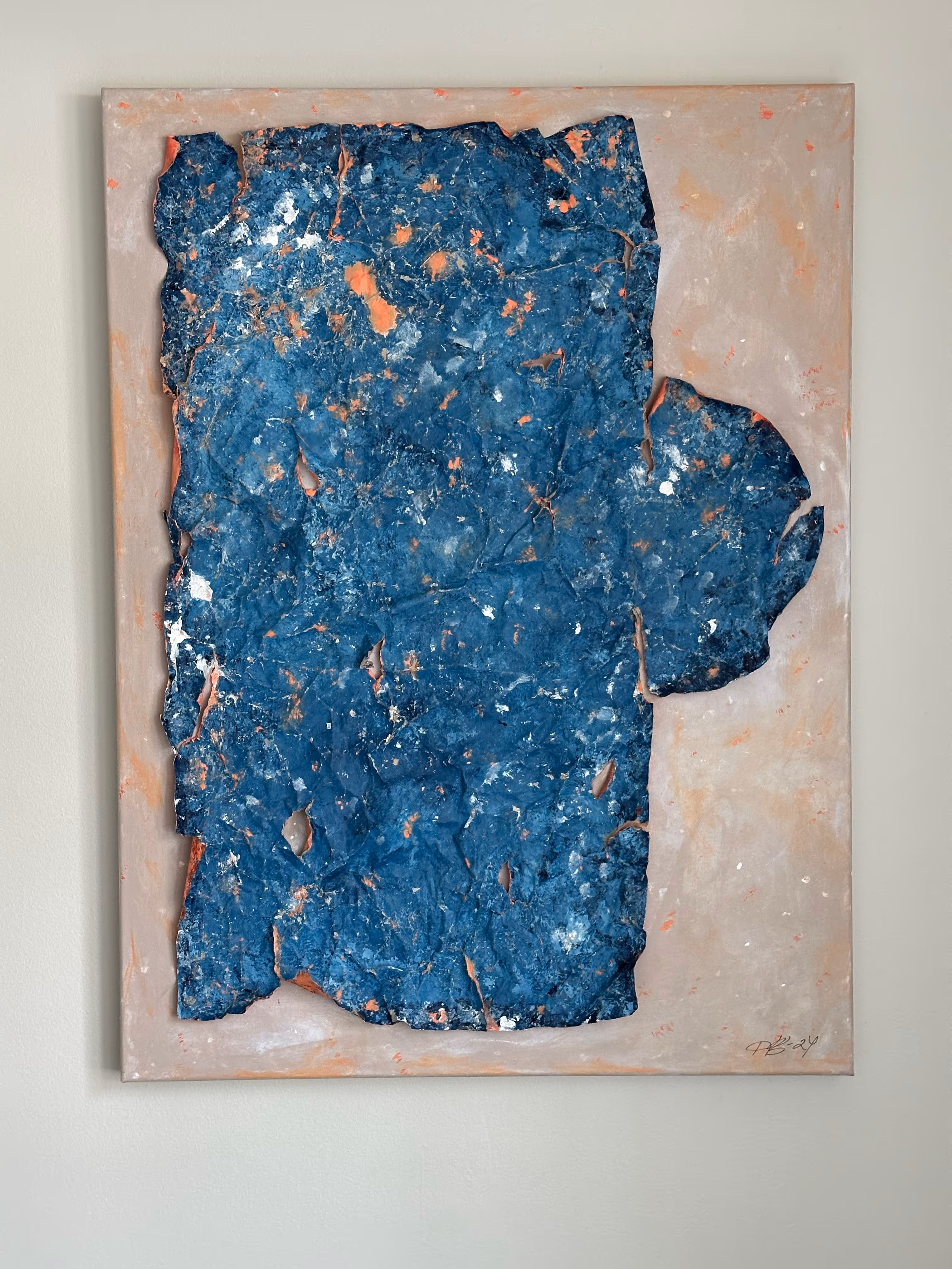 Abstract textured painting with irregular blue and orange shapes on a muted beige background.