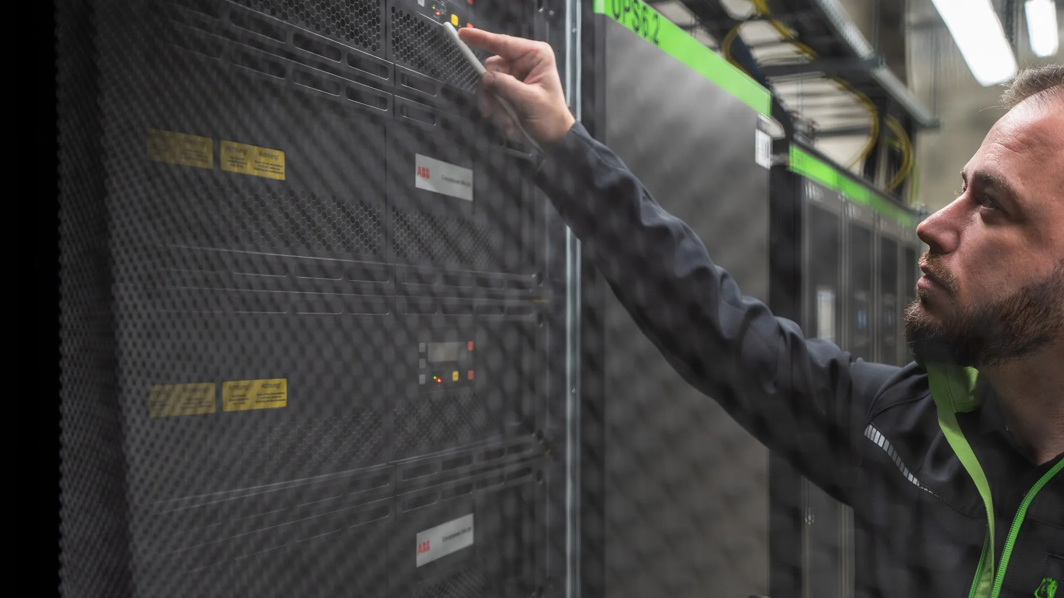 Technik provádí údržbu serveru za kovovou mříží v datovém centru.