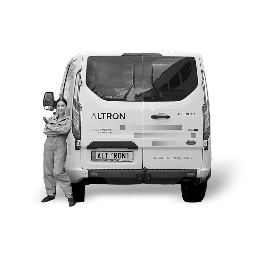 Žena v pracovním oblečení stojí opřená o zadní část bílého dodávkového vozu Ford s nápisem ALTRON a registrační značkou ALT RON1.