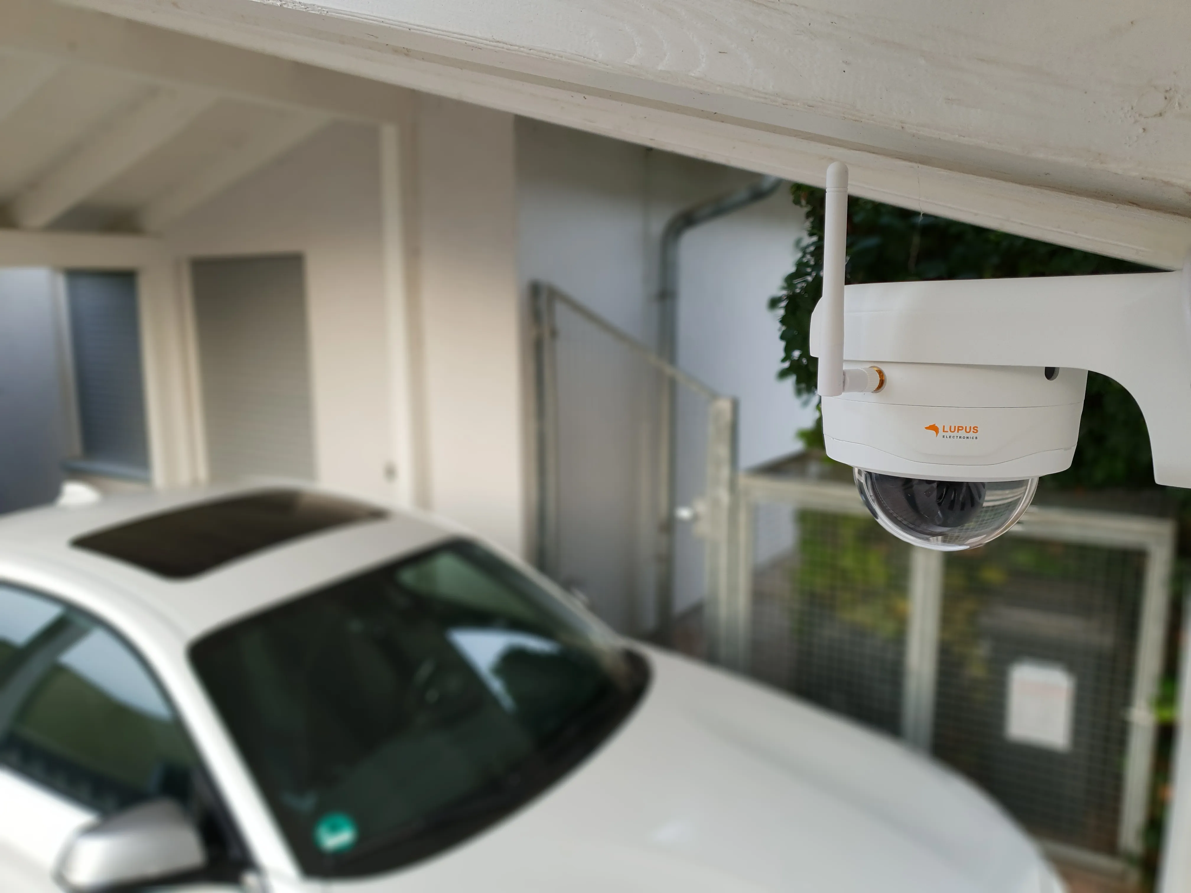 Außenkamera unter einem Dachüberstand mit Blick auf einen geparkten PKW
