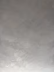 Glatte, hellgraue Betonwand mit sichtbaren Texturen und unregelmäßigen Mustern.