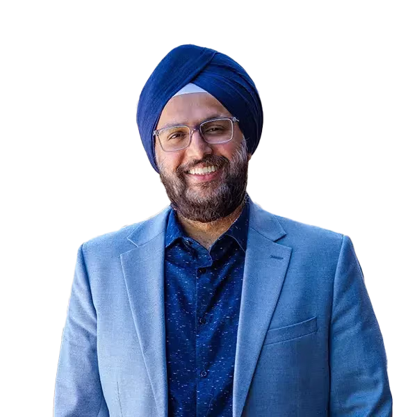 Smiling man wearing glasses, a blue turban, dark blue shirt, and light blue blazer.