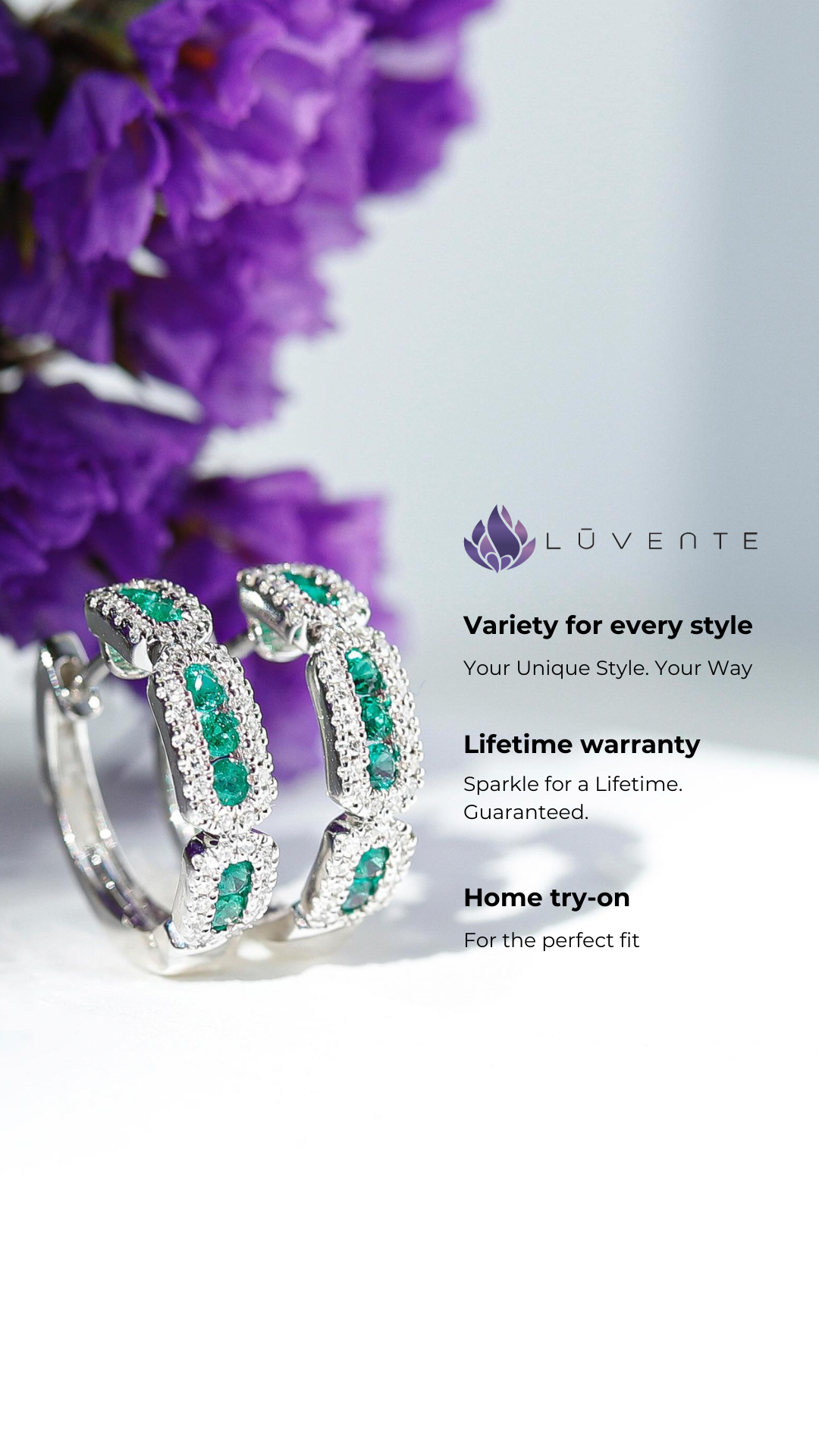 Silver hoop earrings with green gemstones placed on a white surface with blurred purple flowers in the background and Luvente jewelry brand logo with text describing styles, lifetime warranty, and home try-on.