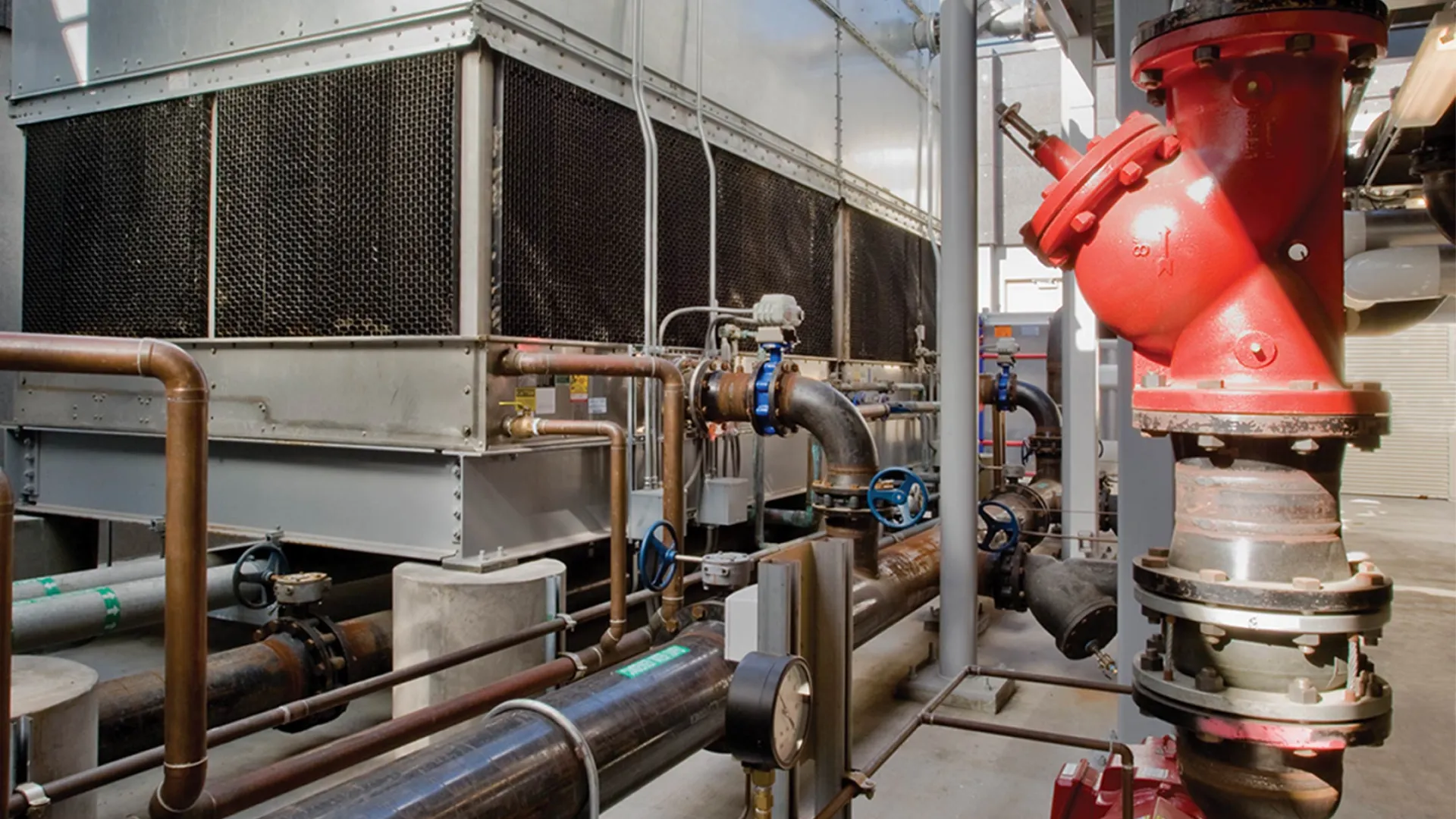 Industrial water-treatment system with pipes, valves and large cooling units.