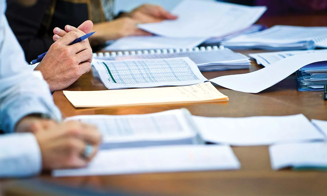 Participants reviewing spreadsheets and notes during a training session.