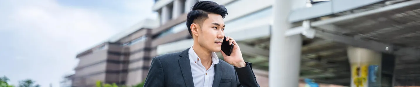 Homem caminhando e falando ao smartphone.