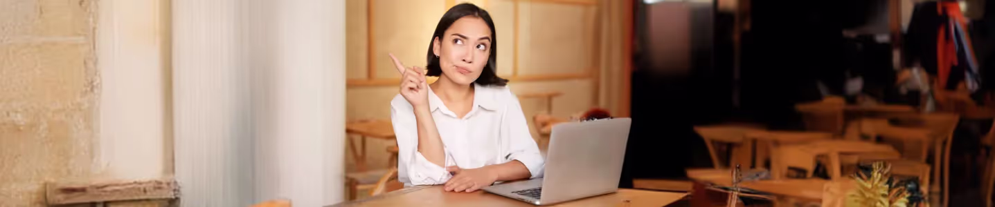 Mulher com notebook pondera se 2 pontos extras Wi-Fi 5 valem a pena.