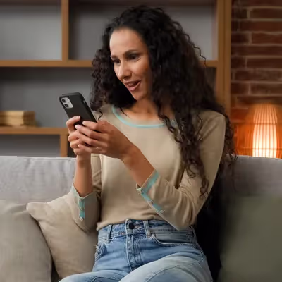 Radiante, a mulher expressa sua felicidade ao encontrar o número 0800 correto da operadora Oi em seu celular, satisfeita por finalmente resolver um problema ou obter informações importantes com facilidade.