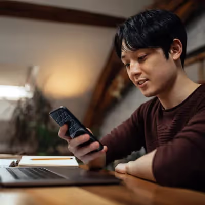 Adolescente hipnotizado por seu smartphone, alheio ao mundo ao redor enquanto mergulha nas maravilhas digitais.