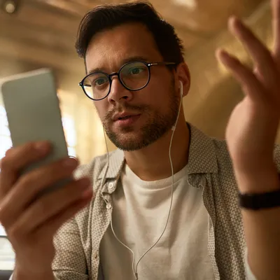 Com uma expressão perplexa, um jovem rapaz tenta solucionar a falta de internet em seu celular, buscando entender e resolver a questão para retomar suas atividades online.