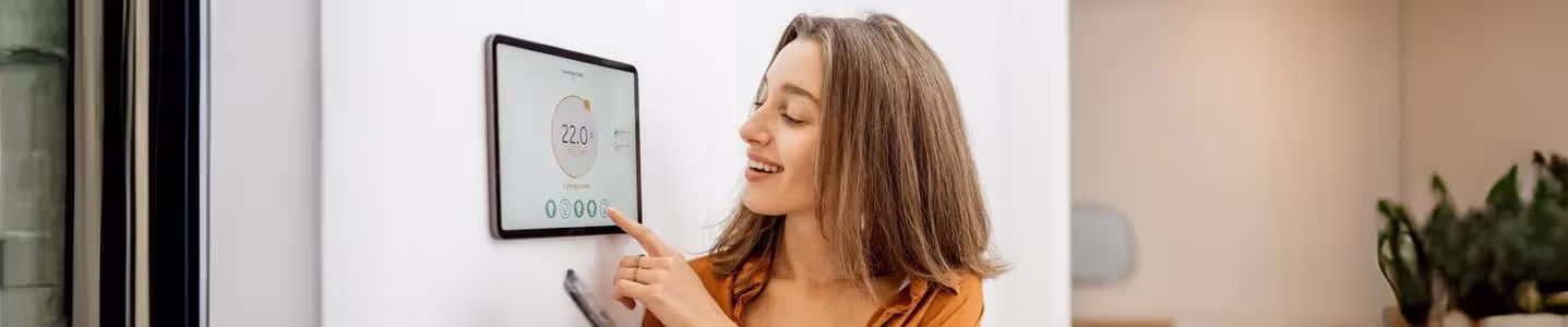 A mulher está feliz usando automação residencial para simplificar sua vida, aproveitando a conveniência e eficiência que essa tecnologia oferece.