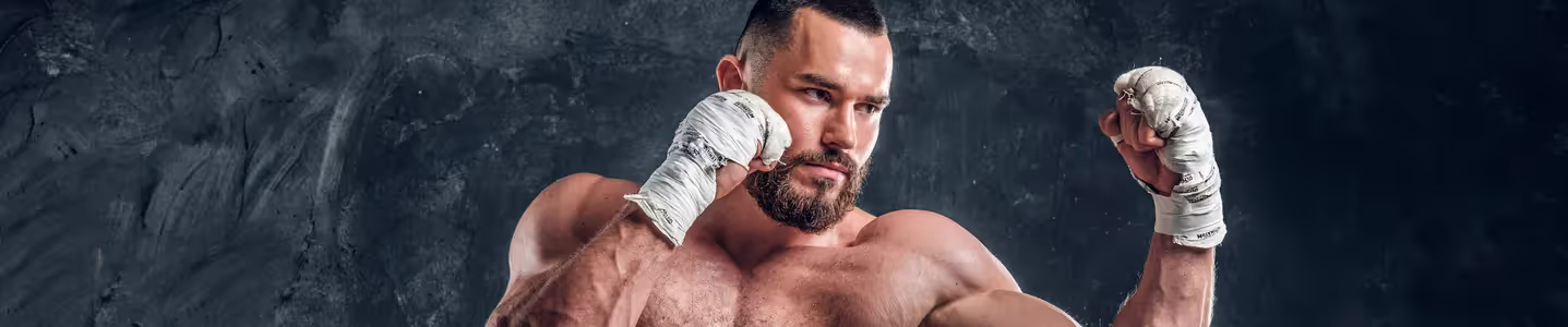 Um lutador do canal Combate está em uma postura de luta, mostrando sua determinação e habilidade enquanto se prepara para enfrentar seu oponente no octógono.