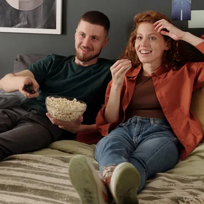 Momento de alegria com casal assistindo TV.