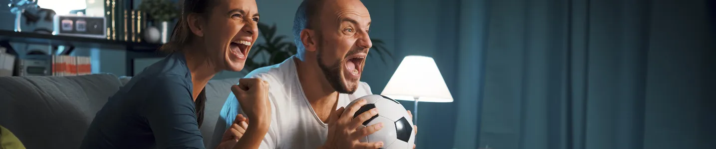 Casal assistindo esportes ao vivo em serviço de streaming.