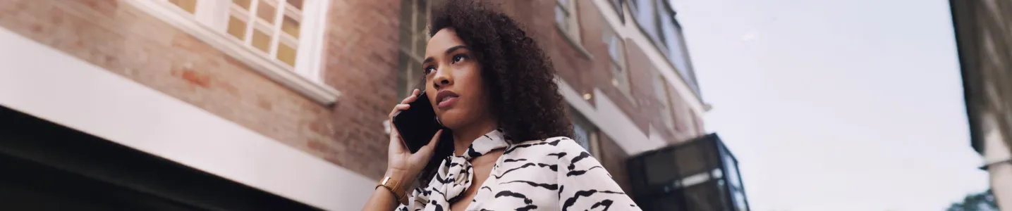 Mulher atendendo ligação de telemarketing com expressão neutra.