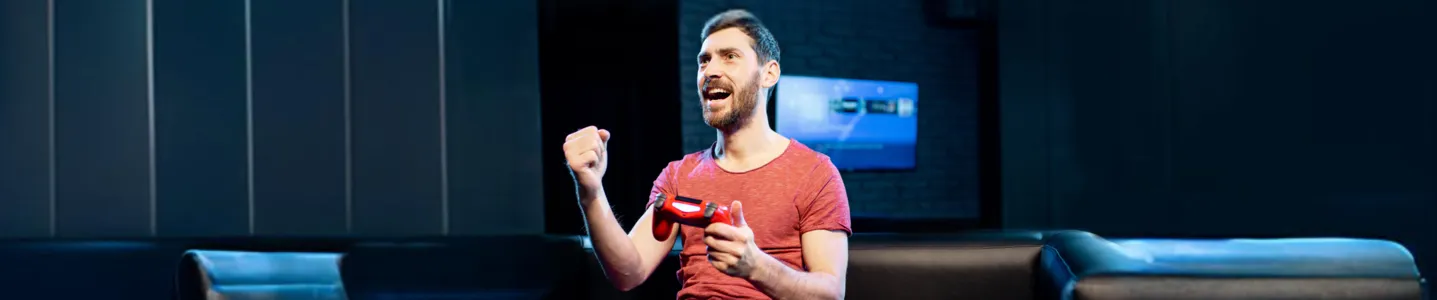 Homem jogando no PS5, imerso na partida.