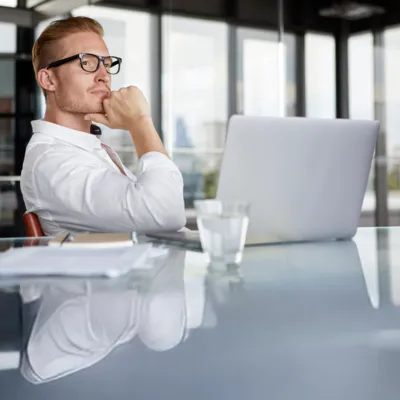 Reflexão de homem enquanto usa o notebook.