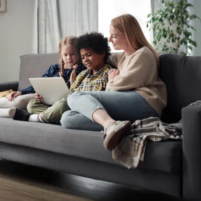 Mãe acompanhando filhos vendo tablet.