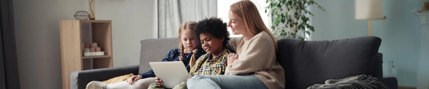 Mãe supervisionando dois filhos assistindo no tablet.