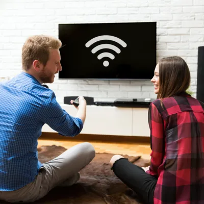 Casal configura o Wi-Fi na TV.