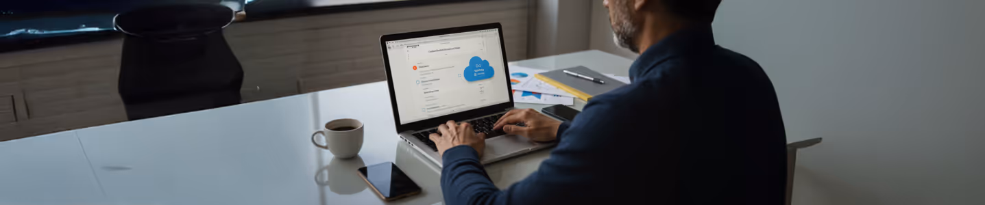 Homem usando laptop para navegar em plataforma de armazenamento em nuvem.