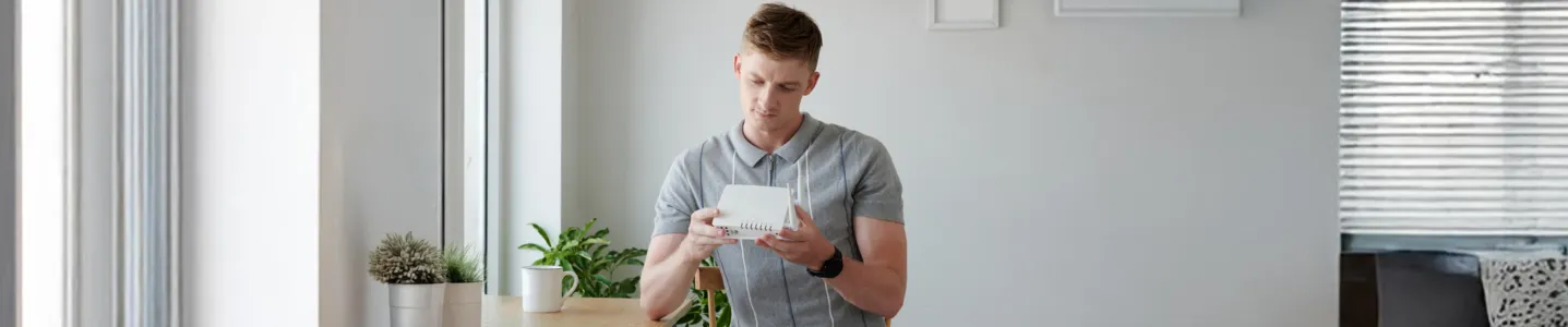 Homem configurando roteador para melhorar videochamadas.