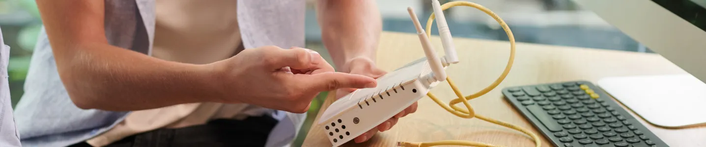 Rapaz diagnosticando problemas de conexão no roteador Wi-Fi.