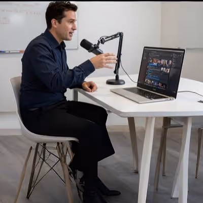 Apresentador de podcast falando diante de notebook