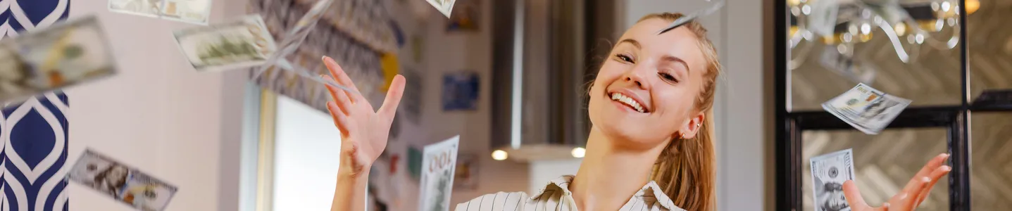 Uma mulher joga notas de dinheiro para o ar, simbolizando seu sucesso com ganhos financeiros na internet, mostrando sua realização e prosperidade por meio das oportunidades online.